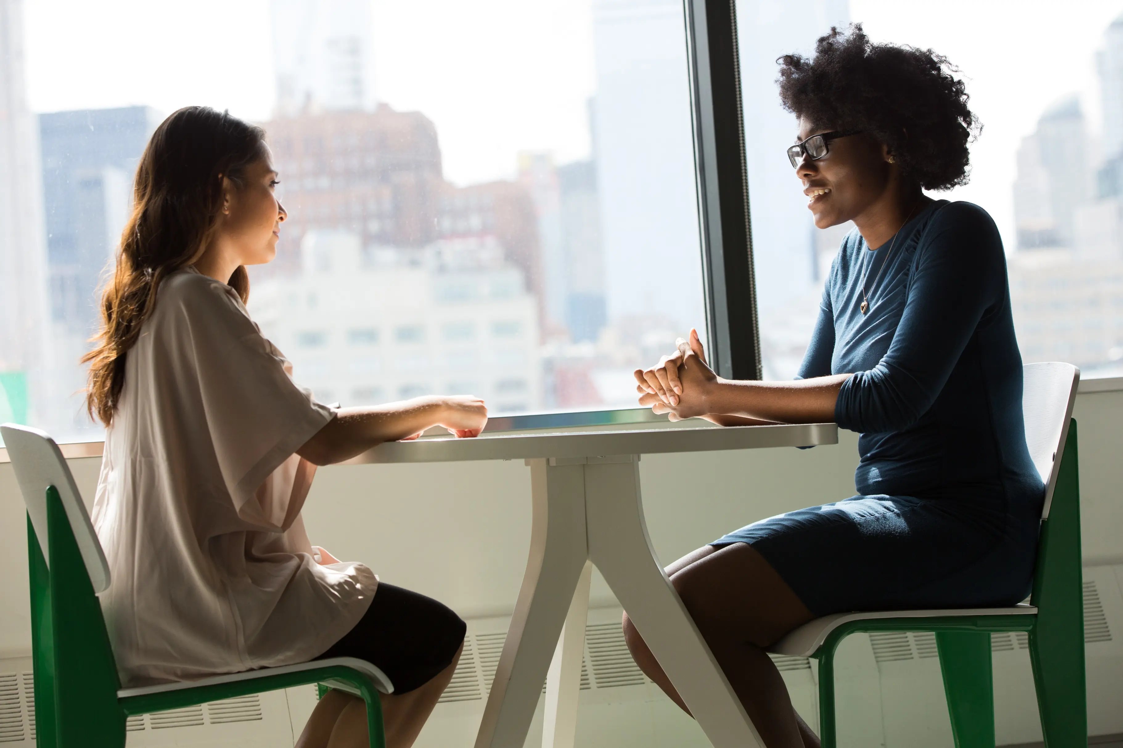 Entretien de coaching professionnel en visio : deux personnes échangent autour d’une table